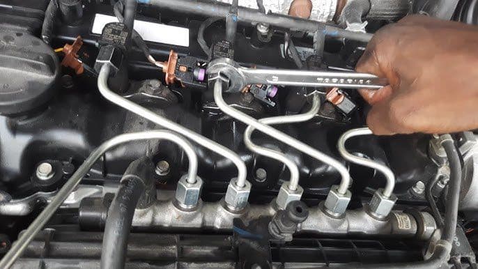 Mechanic working on a car engine using a wrench at Handy Speedy Mechanical Workshop in Hull